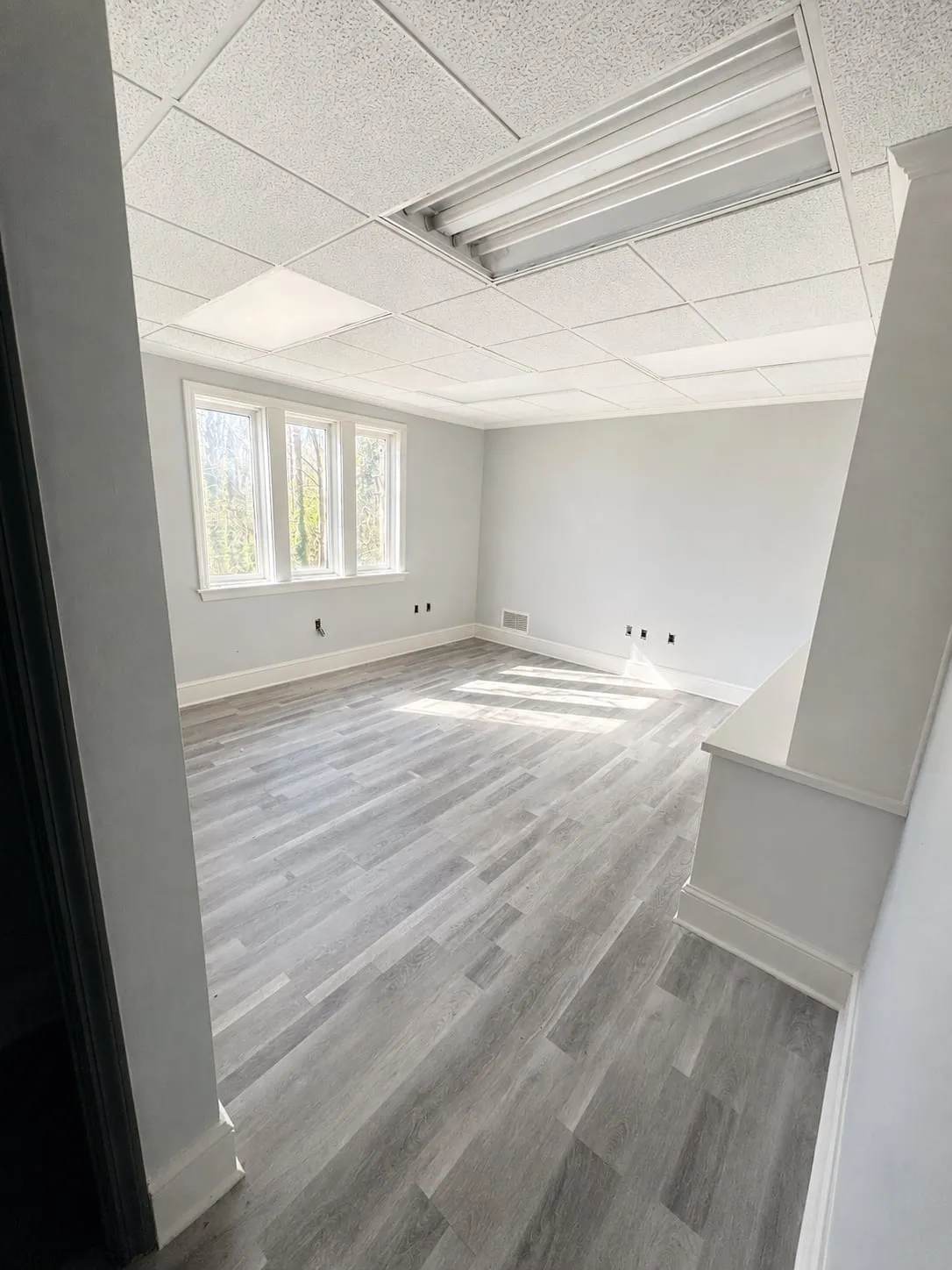 Renovated office suite with new plank flooring, fresh paint, and triple window at 125 Dillon Drive